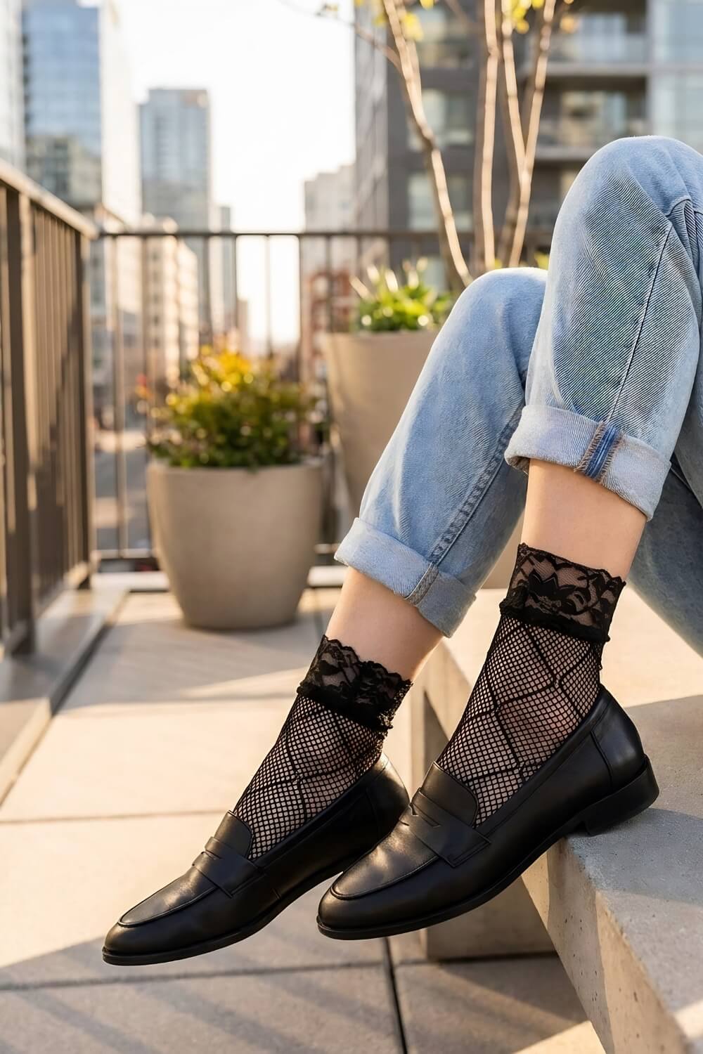 Diamond Lace Fishnet Socks featuring a fine fishnet weave with bold diamond-pattern detailing and delicate floral lace cuffs, styled with rolled light-wash jeans and black loafers on a rooftop terrace with a city skyline backdrop in warm golden sunlight for a chic street-style look.