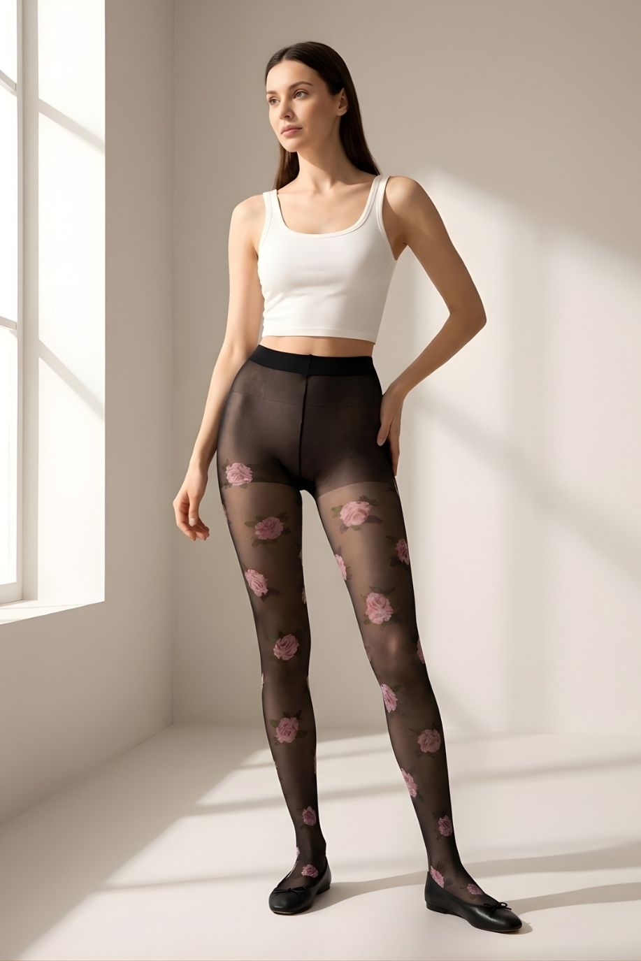 Romantic Rose Print Sheer Tights featuring a lightweight black transparent fabric with soft stretch fit and scattered pink rose pattern, shown full-length on a model in a minimal sunlit studio setting.