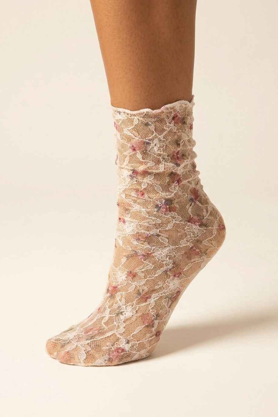 Floral Mesh Sheer Socks in pink floral lace mesh, shown on one foot with ruffled crew cuff and white lace detailing.