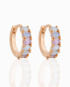 Dreaming About You Hoops featuring small hinged hoop earrings with pastel oval stone accents and gold tone prong setting, captured on a clean reflective backdrop, highlighting curved shape, delicate shine, and gift ready presentation.