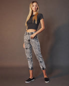 Woman in black crop top and acid-wash jeans, casual fashion by Love Classic