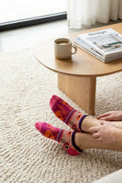 Shine Ultra-Short Ankle Socks featuring a soft, lightweight knit with bright floral and stripe detailing, worn while relaxing on a plush rug in a sunlit living space, emphasizing easy all-day wear and cheerful style.