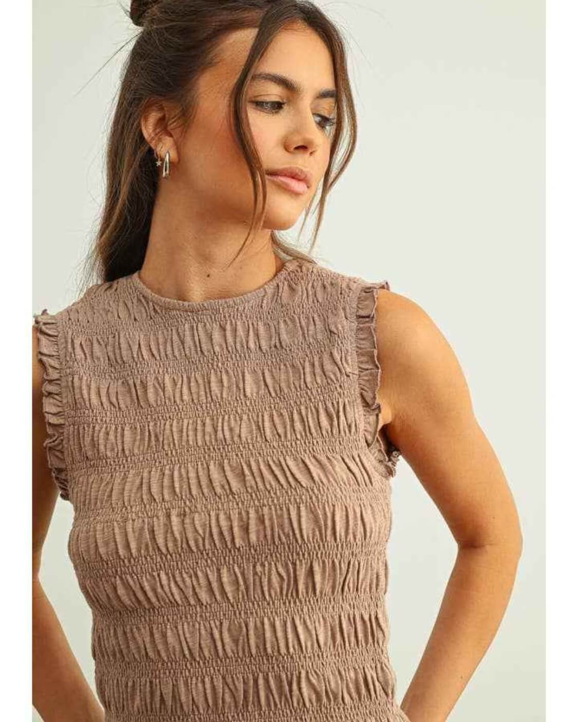 Sleeveless with All Over Smocking Top featuring gathered all over smocking with delicate ruffle sleeve edges and a fitted sleeveless silhouette, shown in a close up portrait pose against a soft studio background, emphasizing textured stitching and casual everyday styling.