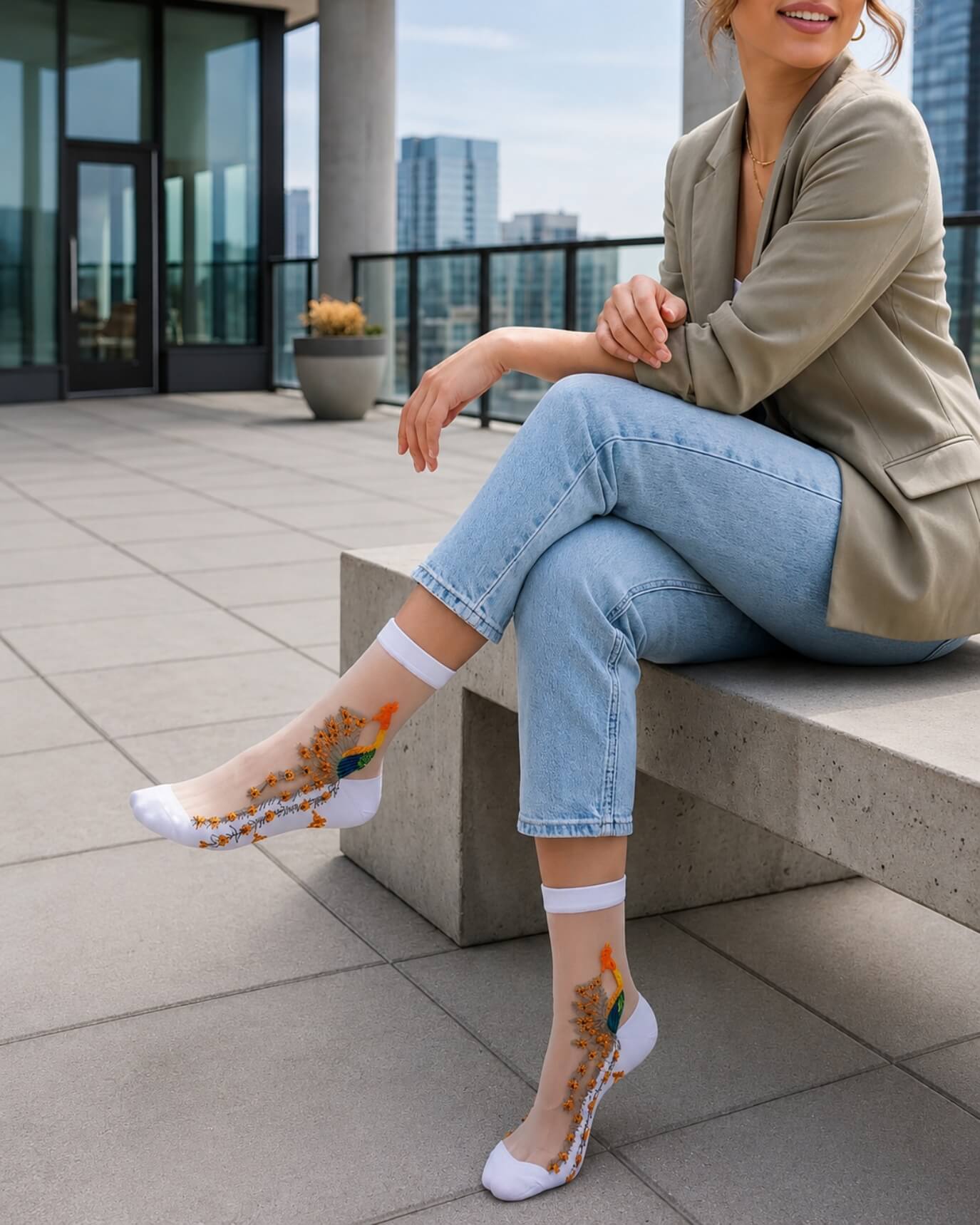 4-Pack Peacock Sheer Mesh Socks featuring sheer mesh construction with embroidered peacock detailing and soft white ankle cuffs, worn with casual denim and a blazer on a rooftop terrace, highlighting the breathable fit and elegant modern styling.