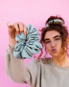Model styled with the Eucalyptus Jumbo Scrunchie on a pink background highlighting the jumbo silhouette and smooth matte sateen texture.