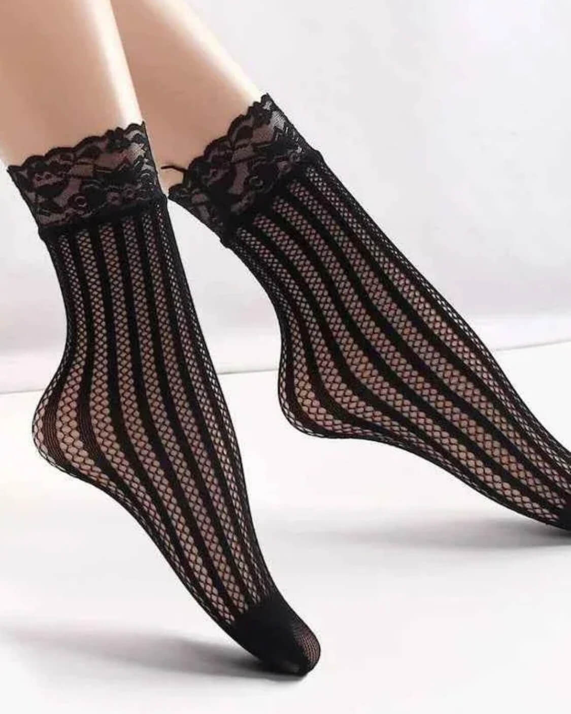 3-Pack Romantic Floral Fishnet Socks featuring sheer black floral lace mesh with scalloped ankle cuffs, worn in a raised leg pose against a soft neutral backdrop, emphasizing breathable texture and graceful styling.
