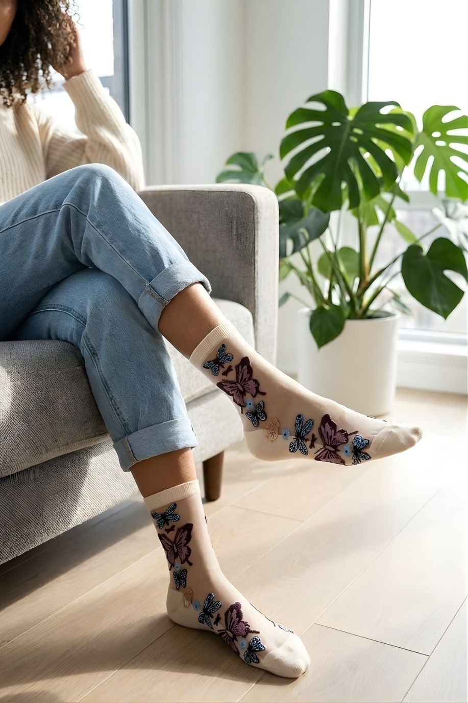 Butterfly Sheer Socks 2-Pack featuring soft sheer fabric with vibrant butterfly embroidery, styled in a cream color with casual denim in a sunlit indoor setting.