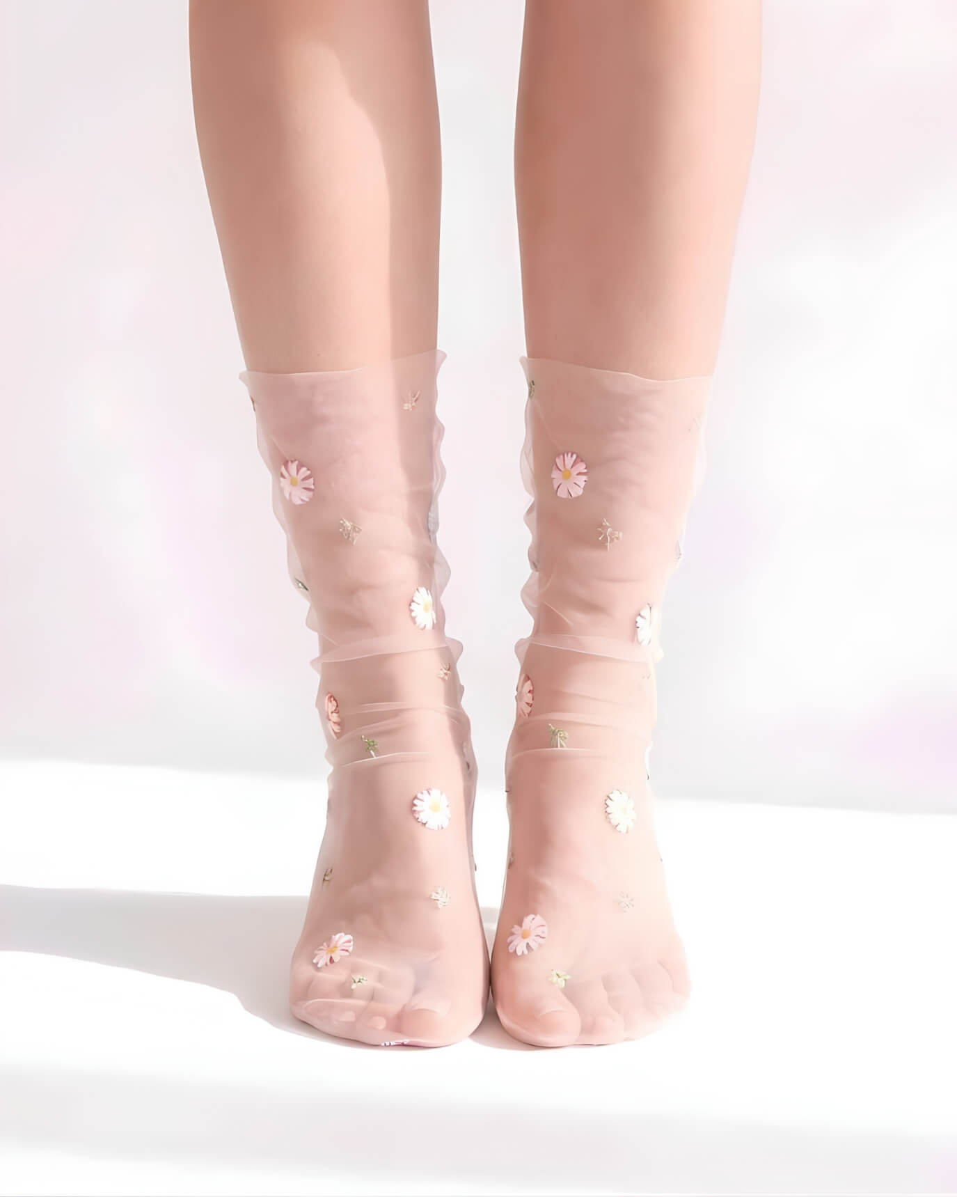 Sheer Garden Daisy Crew Socks in pink sheer fabric with scattered daisy embroidery, front view on both feet to showcase floral detailing and soft texture.