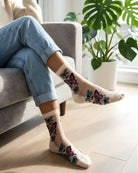 Butterfly Sheer Socks 2-Pack featuring soft sheer fabric with vibrant butterfly embroidery, styled in a cream color with casual denim in a sunlit indoor setting.