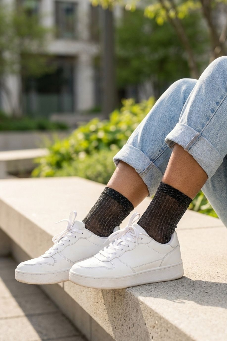 Sheer Metallic Ribbed Crew Socks in black with fine sparkle finish, paired with cuffed denim and white sneakers on outdoor steps, emphasizing the soft stretch fit and delicate ribbed detailing.