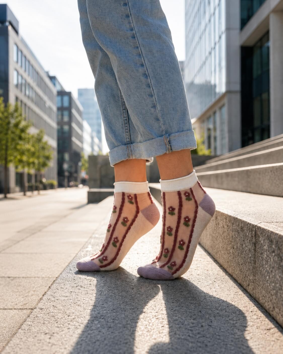2 Pack Maroon Floral Sheer Ankle Sock featuring sheer mesh fabric with vertical floral embroidery and soft contrast toe detailing, worn with cuffed denim jeans while standing on modern city steps, highlighting lightweight comfort and stylish casual wear.
