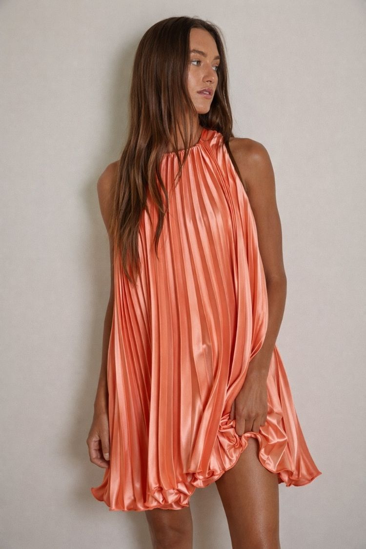 Woman wearing a sleeveless pleated coral mini dress, Love Classic fashion style