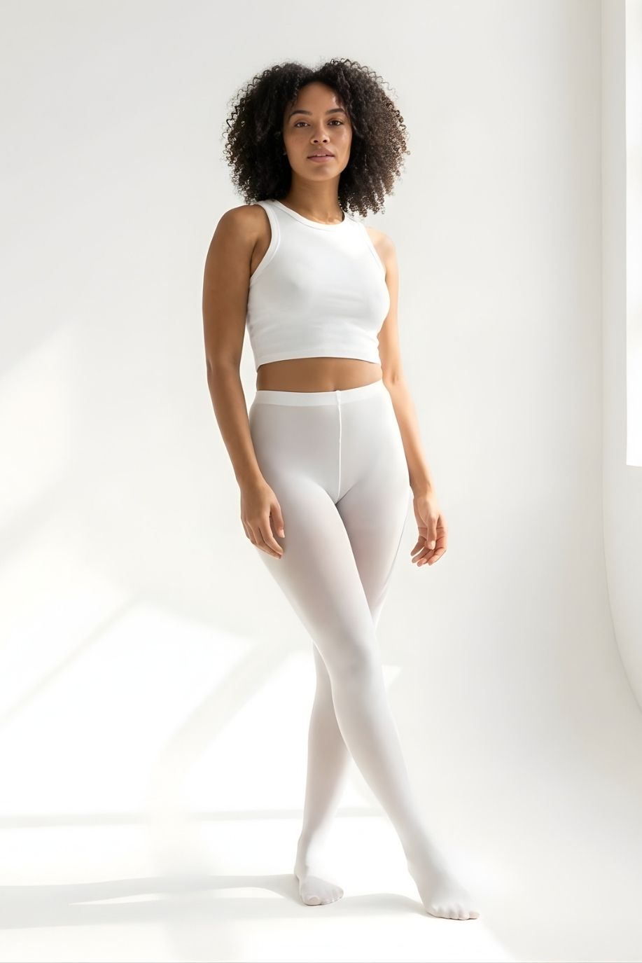 Lightweight Semi Opaque Tights in white, featuring a soft semi-opaque finish with a sleek high-rise waistband, shown full-length on a model in a bright minimalist studio.