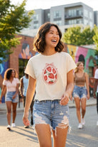 High Rise Distressed Denim Shorts featuring a high waist design with distressed accents and frayed hem, styled on a sunny street with mural background, highlighting the comfortable fit and casual street style.
