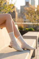 Sheer Floral Lace Crew Socks in ivory featuring soft floral lace detailing, paired with neutral-toned loafers and styled on outdoor steps, emphasizing the airy, semi-sheer fabric and feminine look.
