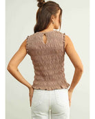 Sleeveless with All Over Smocking Top featuring a fully smocked back with ruffle trim accents and a small keyhole button closure, captured from the rear with high waisted jeans in a relaxed standing pose, highlighting flexible texture and detailed back finishing.