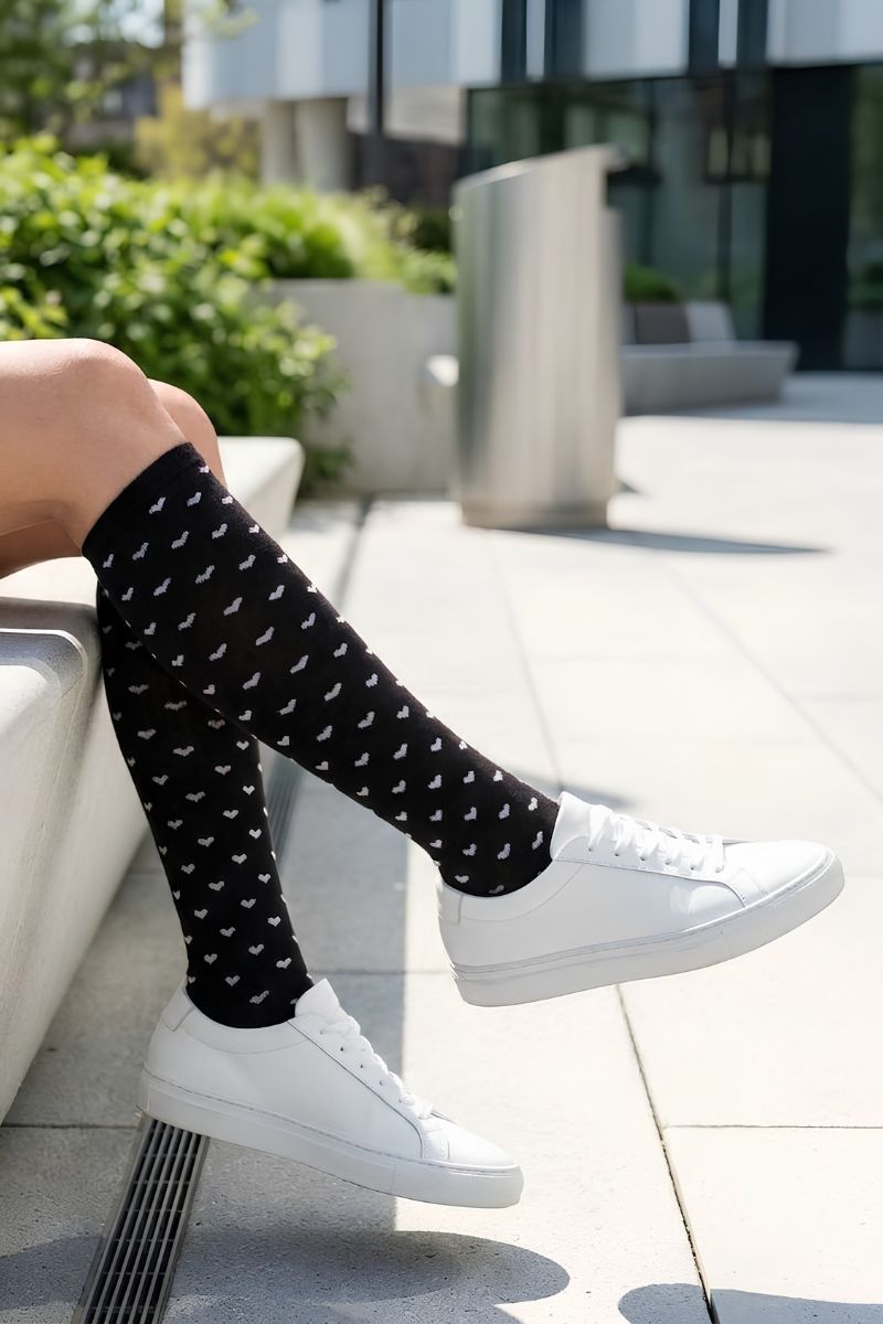 Heart Knee High Socks featuring a comfortable stretch construction with delicate heart prints and full knee-high coverage, paired with sneakers in a bright outdoor setting to emphasize versatility, comfort, and effortless styling.