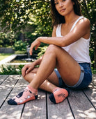 Shorty Socks, Wine Down featuring wine bottle, glass, and corkscrew-inspired graphics with a low cuff and contrast toe panels, worn while seated on a wooden deck, highlighting the fun print and easy everyday comfort.