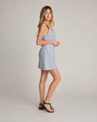 Dahlia Stripe Linen Dress, full body side view highlighting the relaxed silhouette, mini cut, and structured neckline paired with flat sandals in a minimal backdrop.
