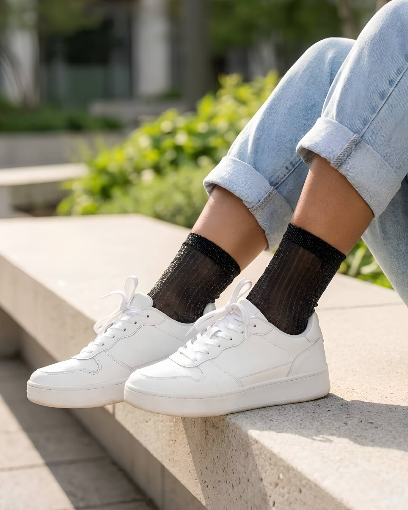 Sheer Metallic Ribbed Crew Socks in black with fine sparkle finish, paired with cuffed denim and white sneakers on outdoor steps, emphasizing the soft stretch fit and delicate ribbed detailing.