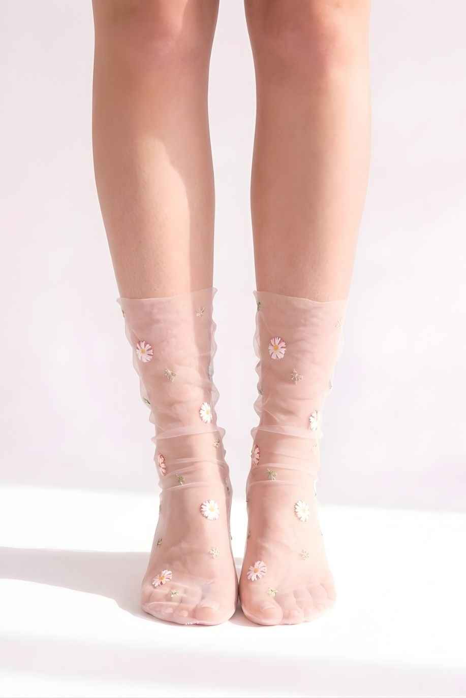 Sheer Garden Daisy Crew Socks in pink sheer fabric with scattered daisy embroidery, front view on both feet to showcase floral detailing and soft texture.