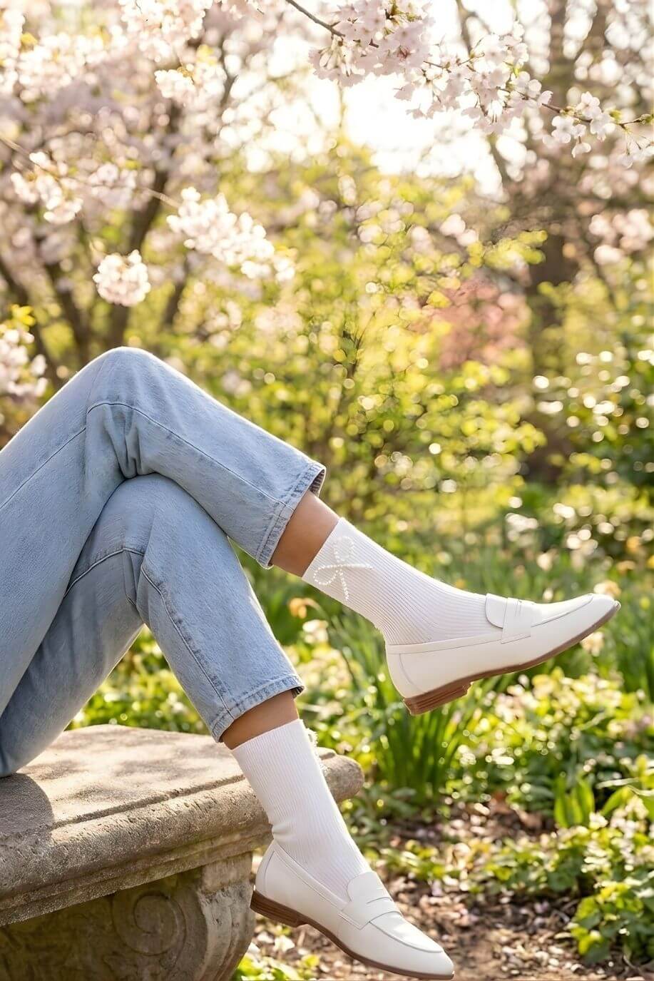 Pearl Bow Classic Ribbed Crew Socks featuring a snug ribbed fit and pearl bow embellishment, worn with white loafers and relaxed denim while seated outdoors in a blooming garden, highlighting a fresh polished style with delicate texture.