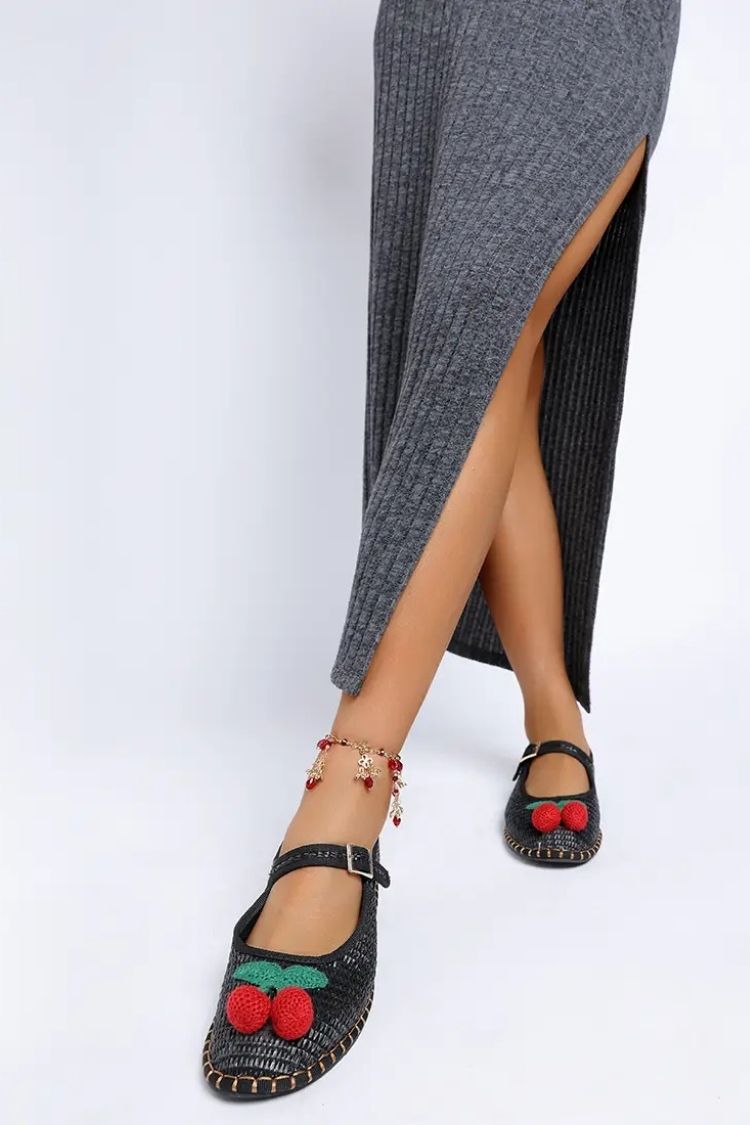 Cherry Accent Mary Jane Flats, black textured Mary Jane flats with cherry accent and buckle strap, paired with a grey slit midi dress and charm anklet, emphasizing the feminine silhouette and everyday styling.