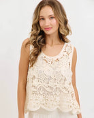Crochet Lace Tank Top featuring a cream floral crochet lace design with scalloped hem, shown on a model with light pants in a studio setting, front portrait view.