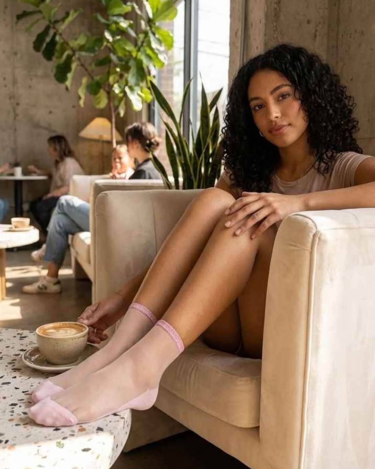 6-Pack Glitter Rim Sheer Crew Socks featuring delicate blush pink sheer mesh with soft shimmer cuffs and reinforced toe accents, worn while relaxing in a bright café lounge, highlighting feminine style and breathable all-day comfort.