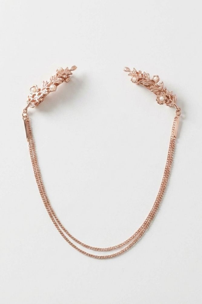 Bloom Bouquets Hair Chain showcasing a rose gold floral hair accessory with detailed leaf motifs, pearl-like accents, and layered draped chains, arranged on a simple white surface to emphasize its elegant silhouette and romantic occasion-ready finish.