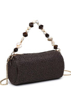 Chocolate Rachel Straw Clutch featuring sculptural bead detailing, polished hardware, and versatile chain strap for clutch or crossbody wear.