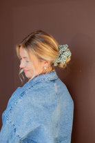 Model wearing the Lindsey Checked Jumbo Scrunchie in hair, highlighting the soft crushed polyester material and classic green check pattern.