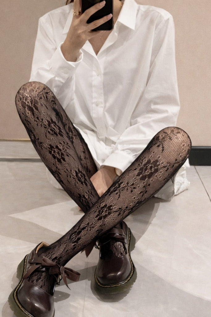 Close-up of black floral lace tights with semi-sheer texture and delicate pattern