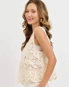 Crochet Lace Tank Top featuring a cream floral crochet lace design with scalloped hem, shown on a model in side profile highlighting the loose fit and texture, studio view.