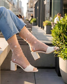 Sheer Garden Daisy Crew Socks in nude sheer fabric with embroidered daisies, styled with heeled mules and jeans in an urban setting.