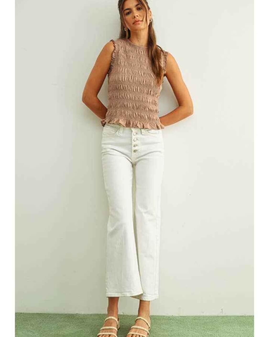 Sleeveless with All Over Smocking Top featuring textured all over smocking with ruffle sleeve trim and a fitted silhouette, styled with cropped jeans and flat strap sandals in a full body standing pose, highlighting casual comfort and lightweight everyday wear.
