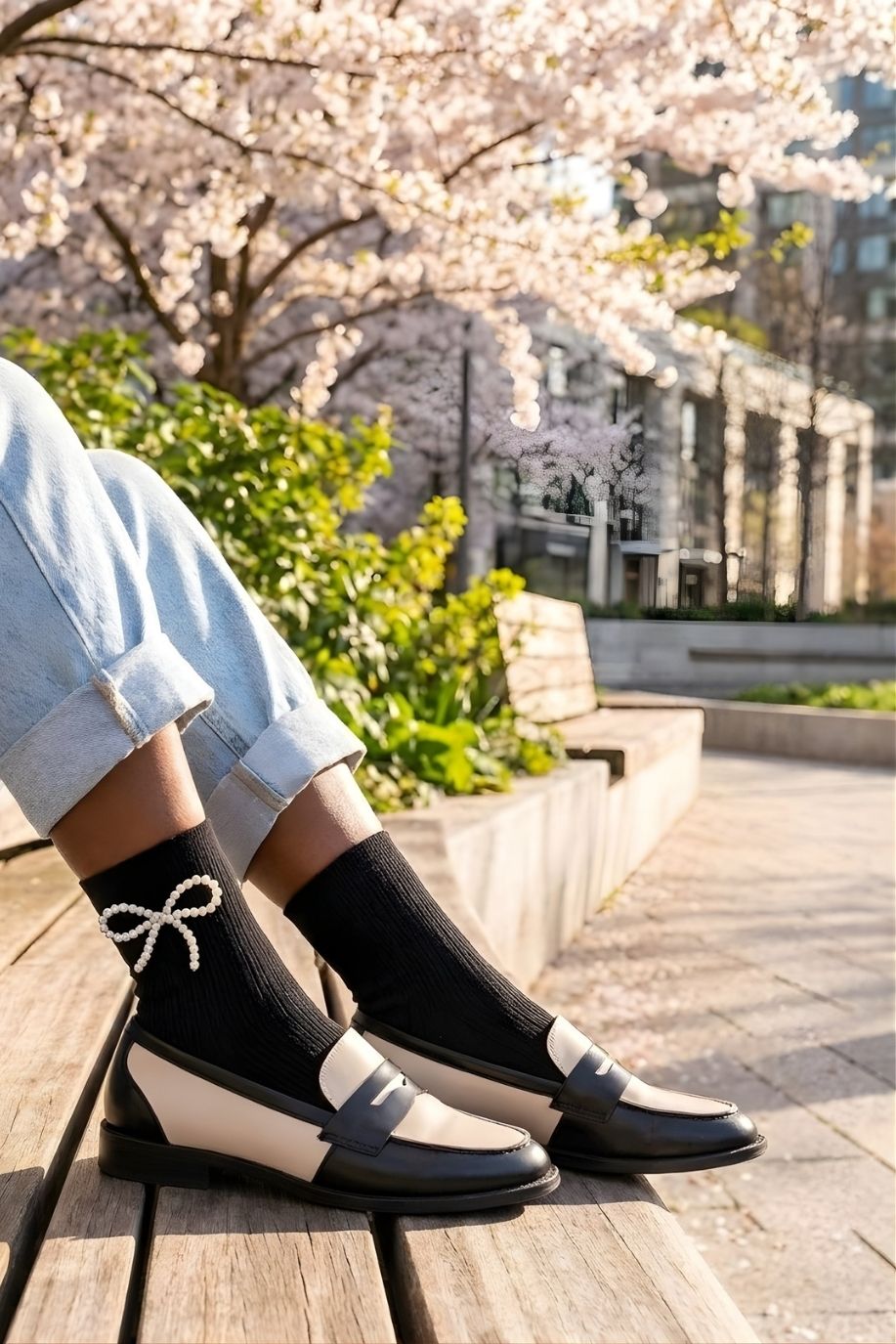 Pearl Bow Classic Ribbed Crew Socks featuring a classic ribbed texture and pearl bow detail at the ankle, styled with loafers and cuffed jeans on a wooden bench in a sunlit outdoor setting, highlighting comfort and a polished casual finish.