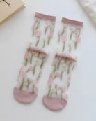 Floral Pattern Sheer Socks 4-Pack featuring soft pink floral prints with green stem accents on transparent mesh fabric, finished with blush cuffs and reinforced toes, highlighting lightweight comfort and romantic everyday style.