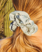 Close-up of the Eucalyptus Jumbo Scrunchie showcasing the smooth sateen fabric, matte finish, and light blue green eucalyptus color.