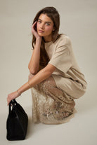 Model wearing the taupe Round Neck Lace Joined T-Shirt Maxi Dress featuring a soft t-shirt bodice, delicate lace detailing, and flowing floor-length skirt.
