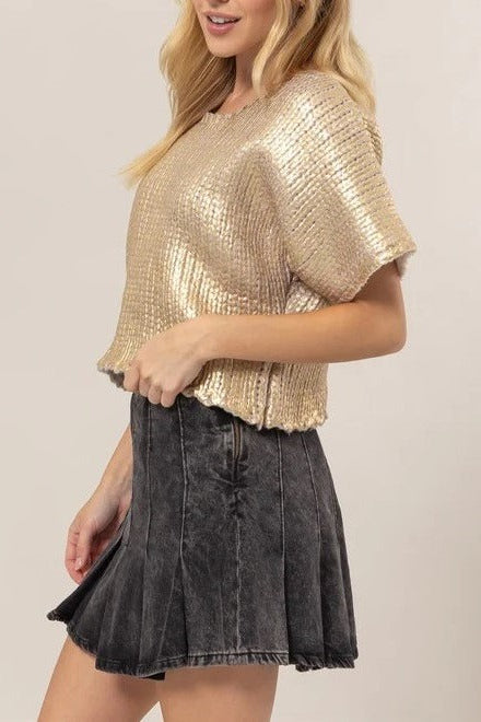 Model styled in the gold Metal Coated Knit Sweater featuring a metal-coated chunky knit finish, figure-flattering bodice, and soft short sleeves.