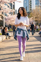 Lightweight Semi Opaque Tights in lavender, featuring a smooth semi-sheer knit and flexible fit, styled with a relaxed tee and sneakers, shown on a model walking through a park with spring blossoms.