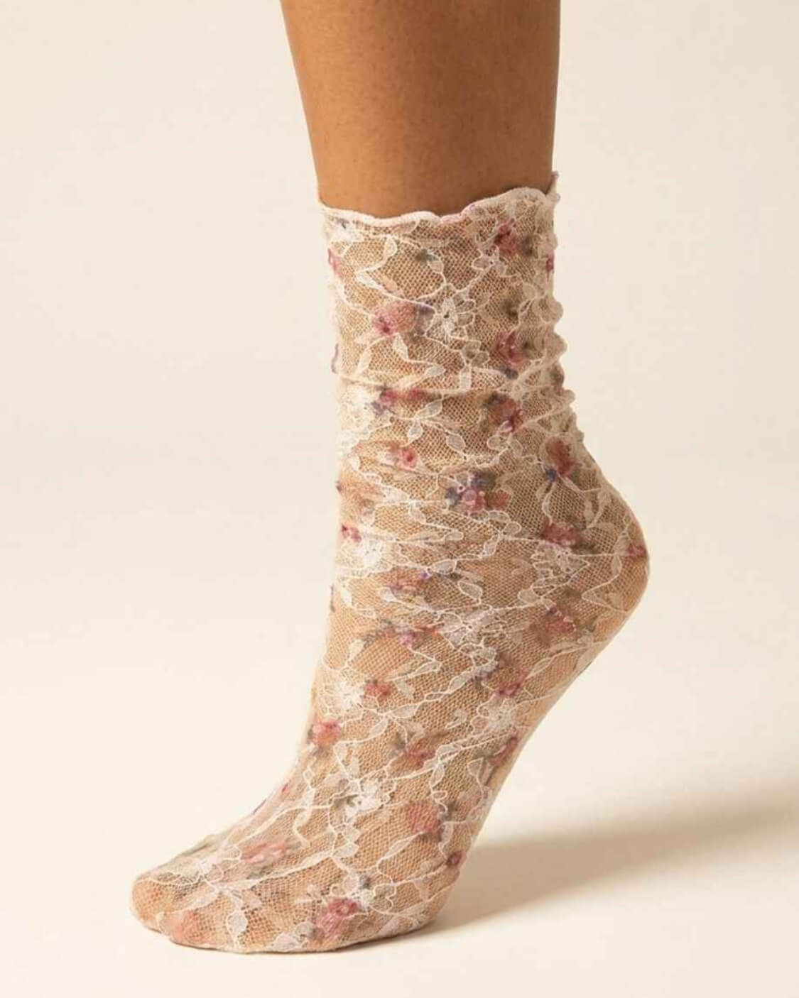 Floral Mesh Sheer Socks in pink floral lace mesh, shown on one foot with ruffled crew cuff and white lace detailing.