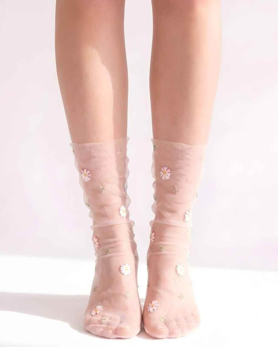 Sheer Garden Daisy Crew Socks in pink sheer fabric with scattered daisy embroidery, front view on both feet to showcase floral detailing and soft texture.