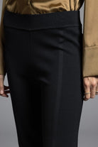 Model pairing black Kick Flare Pants Sasha Pants with a modern outfit, highlighting the sleek fit and seventies-inspired ankle flare.