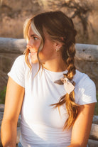 Model styled with the Chestnut Bow Scrunchie in a centipede hairstyle showcasing the elegant bow accent and smooth creamy brown sheen.