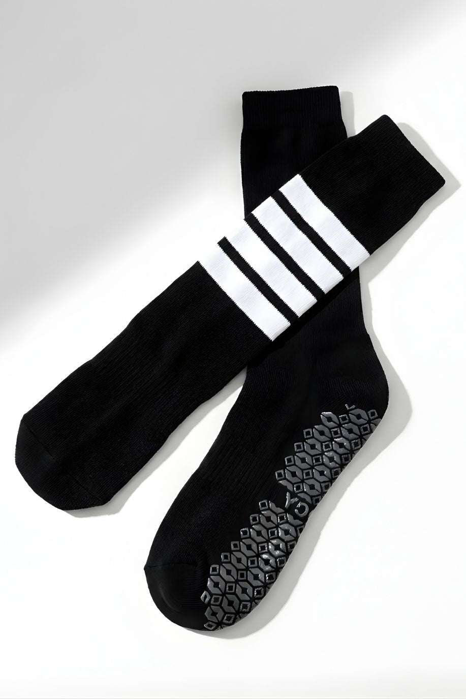 Knee High Yoga Socks featuring a soft knit construction with durable non-slip grip pattern on the soles and bold stripe detail at the top, displayed flat on a clean background, showcasing design and functional features.