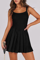 Woman wearing a black dress holding a sport athletic gear in background