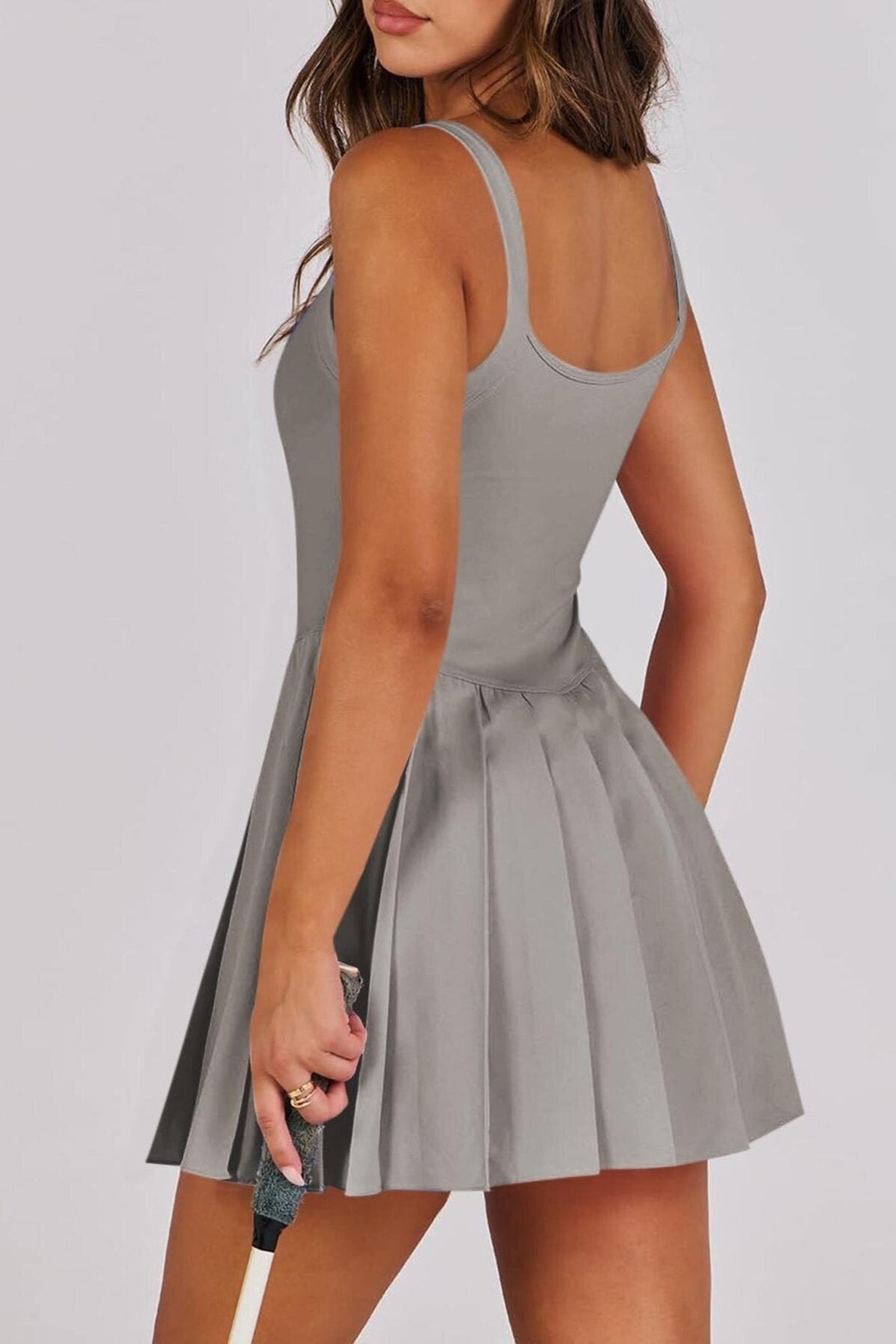 Woman wearing a gray dress with a plain background