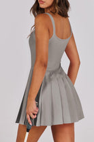 Woman wearing a gray dress with a plain background